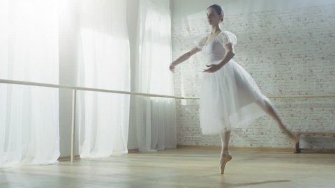 Young and Beautiful Ballerina Dances Energetically but Gracefully on Her Pointe Ballet Shoes, She's Spinning. She's Wearing White Tutu Dress. Shot on RED EPIC-W 8K Helium Cinema Camera.