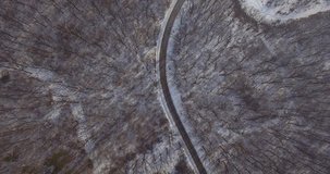 Aerial view of road through winter forest. Aerial view of the forest in winter .Winter landscape.Top down aerial view of snowy trees