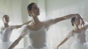 Mid Shot of Three Beautiful and Young Ballerinas Wearing White Tutus and Dancing. Shot Taking Place on a Sunny Morning in a Bright Studio. In Slow Motion.  Shot on RED EPIC-W 8K Helium Cinema Camera. - Powered by Shutterstock - Get 15% off with code: PIKWIZARD15