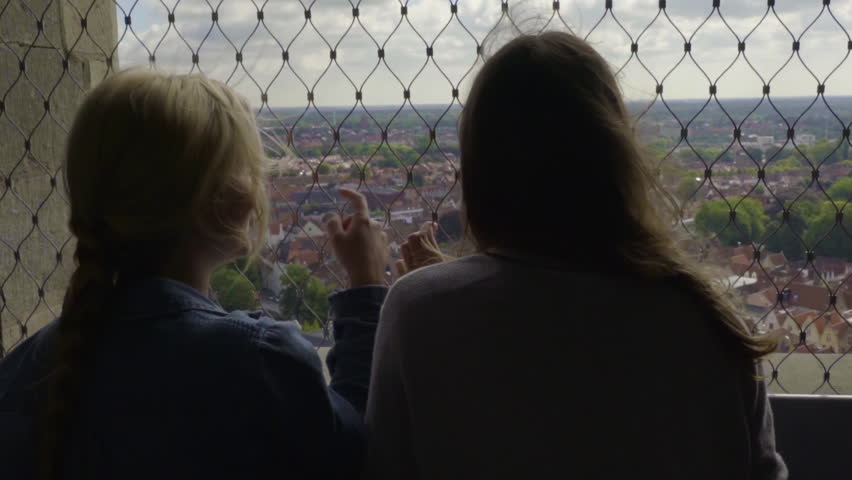 Friends Enjoy The View Of Bruges From The Belfry, A Medieval Bell Tower In Belgium, Blonde Points To Something In Distance