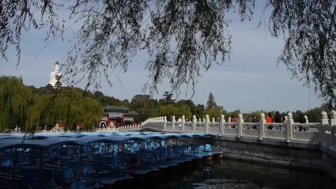 a row of blue boats on lake,swing willow in China Beijing Beihai Park. 