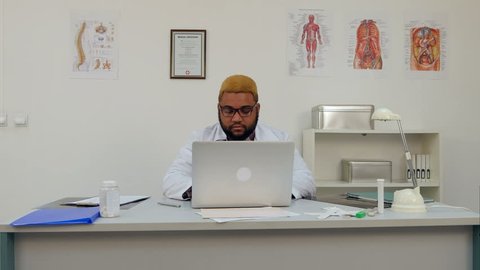 African american male doctor working on laptop