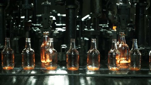 Production of glass bottles. Glass recycling. Bottle manufacturing industrial factory. Molten glass. Glass factory. Automated production line. Furnace. Recycling.