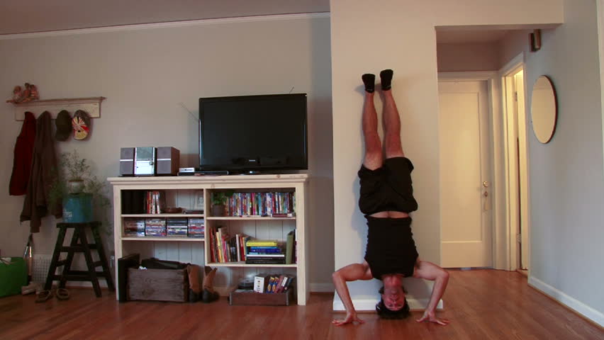 Funny clip of man doing upside down pushups in house.