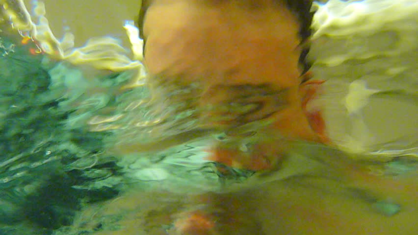 Man dips head into liquid with his eyes open then closes to fall into a visual