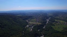Aerial flight over Polovragi commune and green hills, Romania