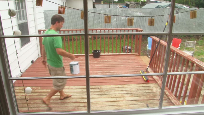 Man paints back deck vibrant red in time lapse.