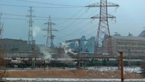 Video of pollution, smoke and steam discharged from a industrial plant. Power transmission line, wires crossing the sky