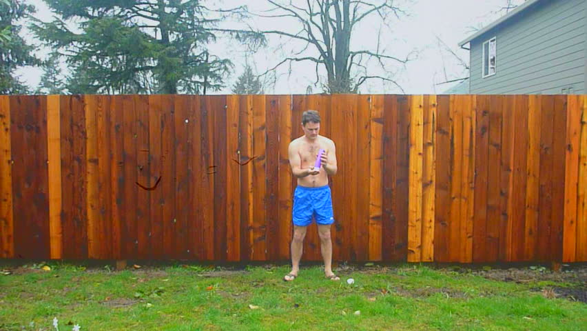Man in blue shorts walks into frame and showers in rainstorm advertisement.