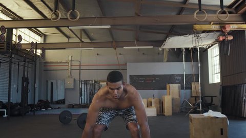 Mixed race man does weight lifting as part of his workout fitness wod in gym