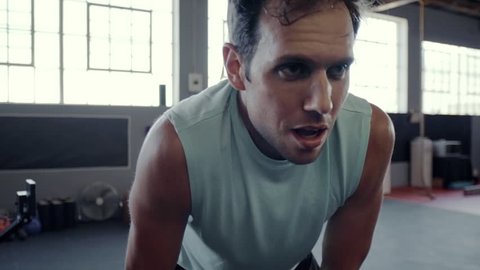 Unfit gym man struggling to keep up with high intensity workout