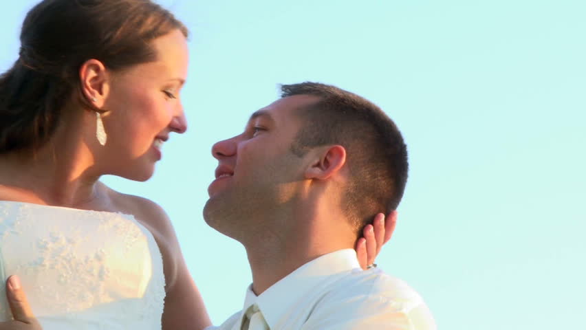 Bride and groom kissing and smiling on their wedding day.