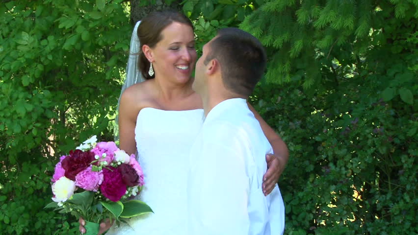 Model released bride and groom kissing and smiling on their wedding day during