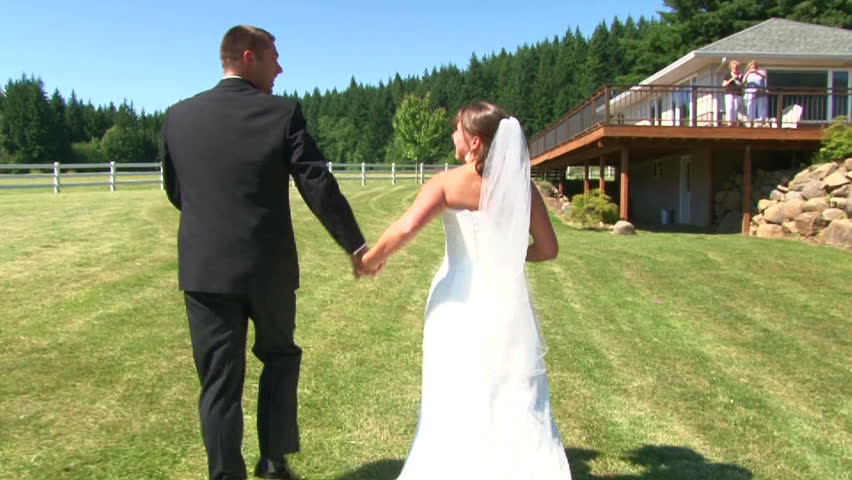 Bride and Groom holding hands and kiss in celebration on their wedding day after