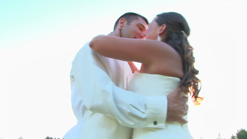 Bride and groom kissing and smiling on their wedding day.