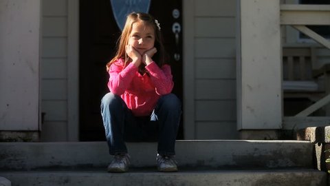 bored little girl sitting on front steps
