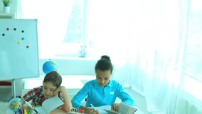 Three cute school children busy doing tasks