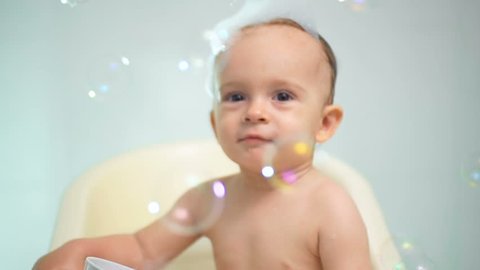 Closeup slow motion footage of baby boy having fun in bathroom