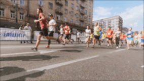Fast video of big crowd of runners running past the camera