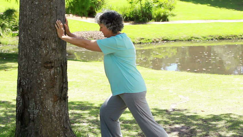 Mature woman doing fitness exercises in the countryside