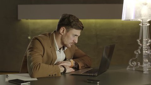 Young businessman inert when sitting in front of his laptop computer