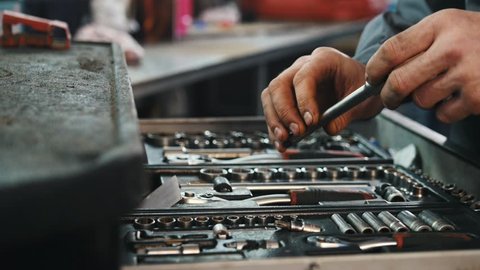 A set of tools for repair in car service - mechanic's hands, close up