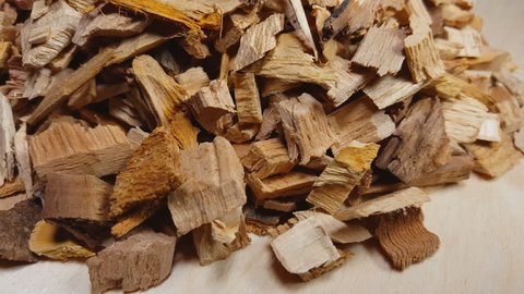 Wood chips for smoking or recycle rotate on the table. Macro shot.