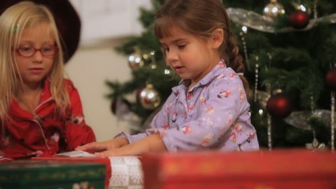 Two little girls opening gifts on Christmas day Stock Video