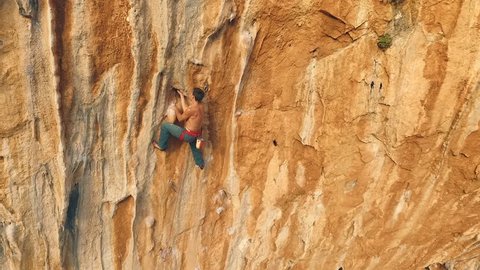 Climber climbs on rock face