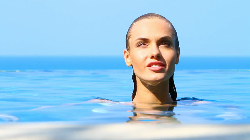 Charming woman reposing in exotic swimming pool

