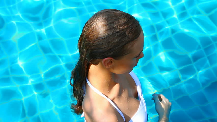 Blonde woman relaxing in swimming pool in summertime

