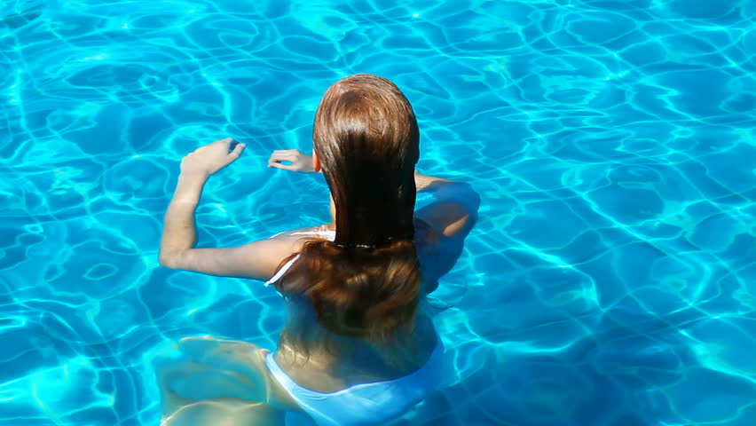 Attractive girl havin fun in outdoor swimming pool

