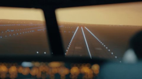 Modern passenger plane descent and landing. Sunset view from the cabin of modern plane to the Airport runway with lighting. Professional male pilots in the cockpit or flight deck control passenger