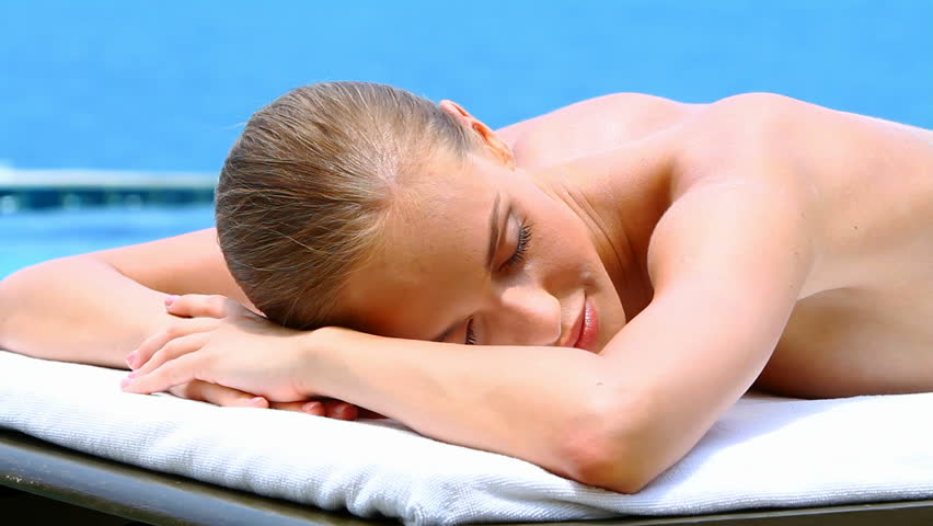 Healthy beautiful woman lying on spa bed at tropical outdoors
