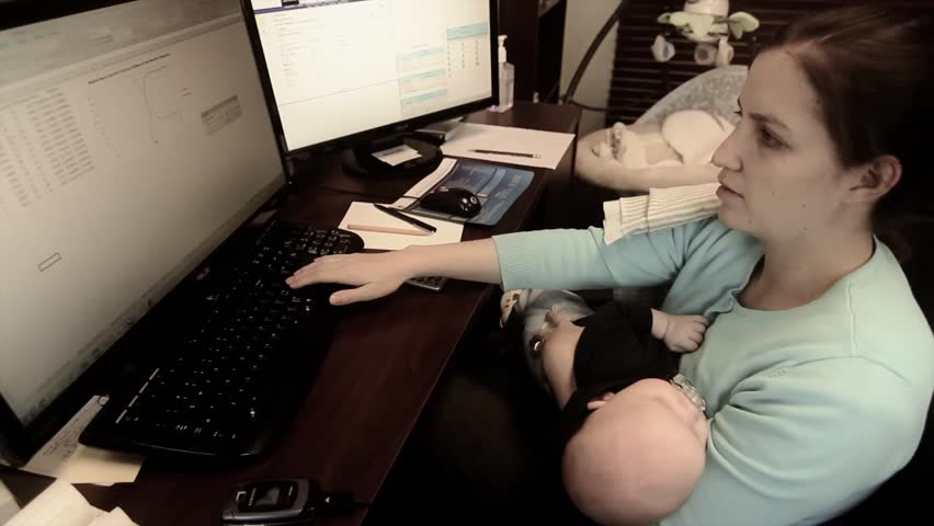 a young mother with her newborn baby working at her office
