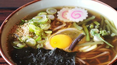 Japanese soba noodle hot soup with green onion, naruto, seaweed and raw egg