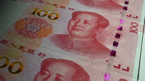 China Yuan banknotes emerging from the money press