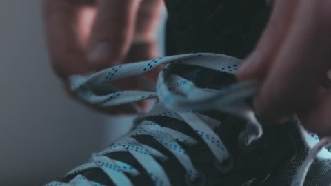 EXTREME CU Caucasian ice hockey player tightening laces on his skates in the locker room, preparing for the game. 4K UHD RAW edited footage Stock Video
