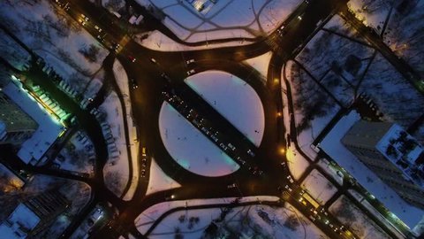 Transport ride through square with roundabout in winter evening. Aerial view