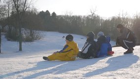 Children sliding downhill on snow disk in wintertime.Children skate downhill