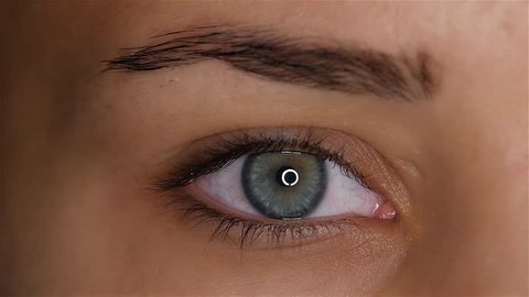 Girl opens her eyes and her pupil increases and narrows. Slow motion. Close up