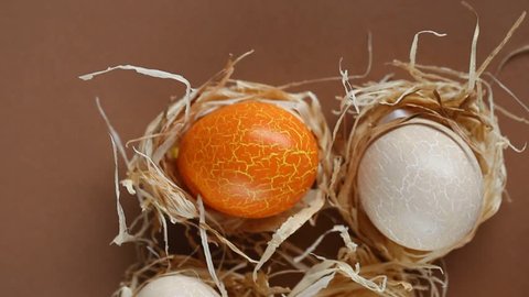 Easter. orange and beige Easter eggs and egg shell on a brown background. chicken escape	