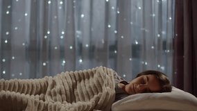 Girl sleeping on a bed at night and waking up with happy emotion. Shot on RED EPIC Cinema Camera.