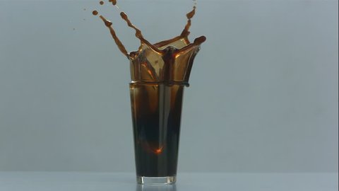 Ice Cube Splashes Into Glass of Nitro Cold Brew Coffee in Slow Motion
