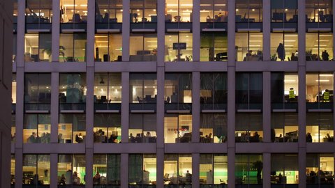 Time-lapse of an office at night panning down to show workers leaving themes of routines working late deadlines