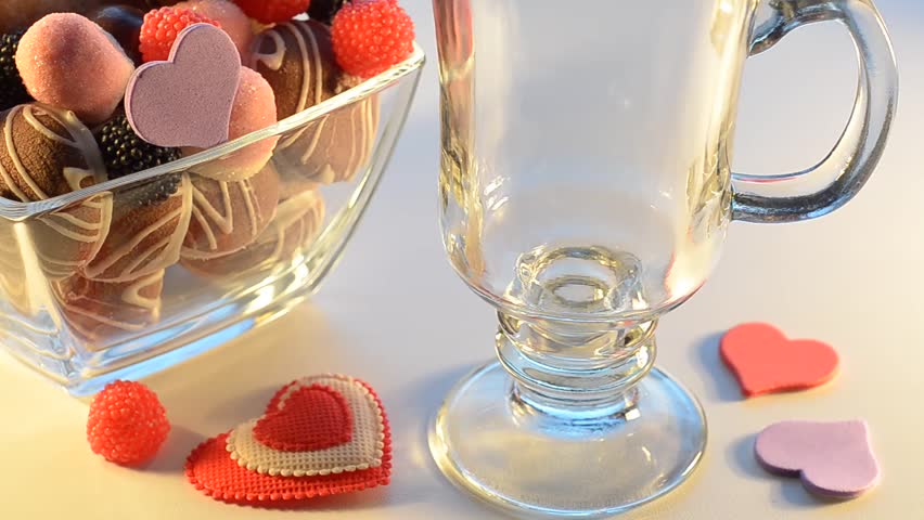Fruit juice poured in a Cup and the candy in the vase. Selective focus.