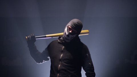 4K Portrait of bandit with mask and baseball bat on black background .