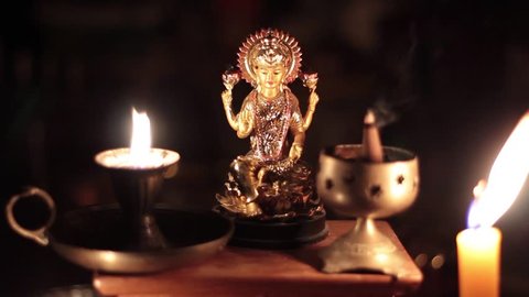 Lakshmi  Devi with candle burning on black background