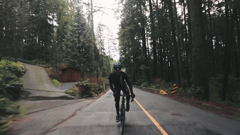 Man Cycling in Vancouver Rainforest Roads