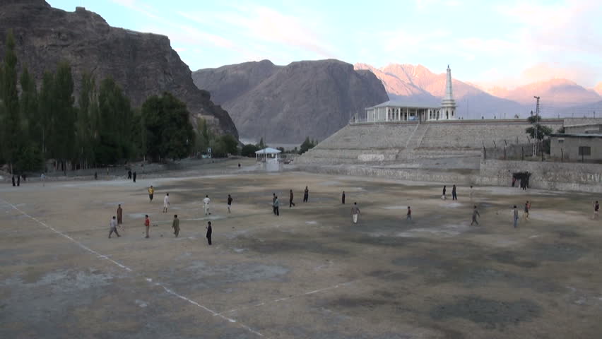 People are playing cricket and soccer on a field in Skardu, Pakistan